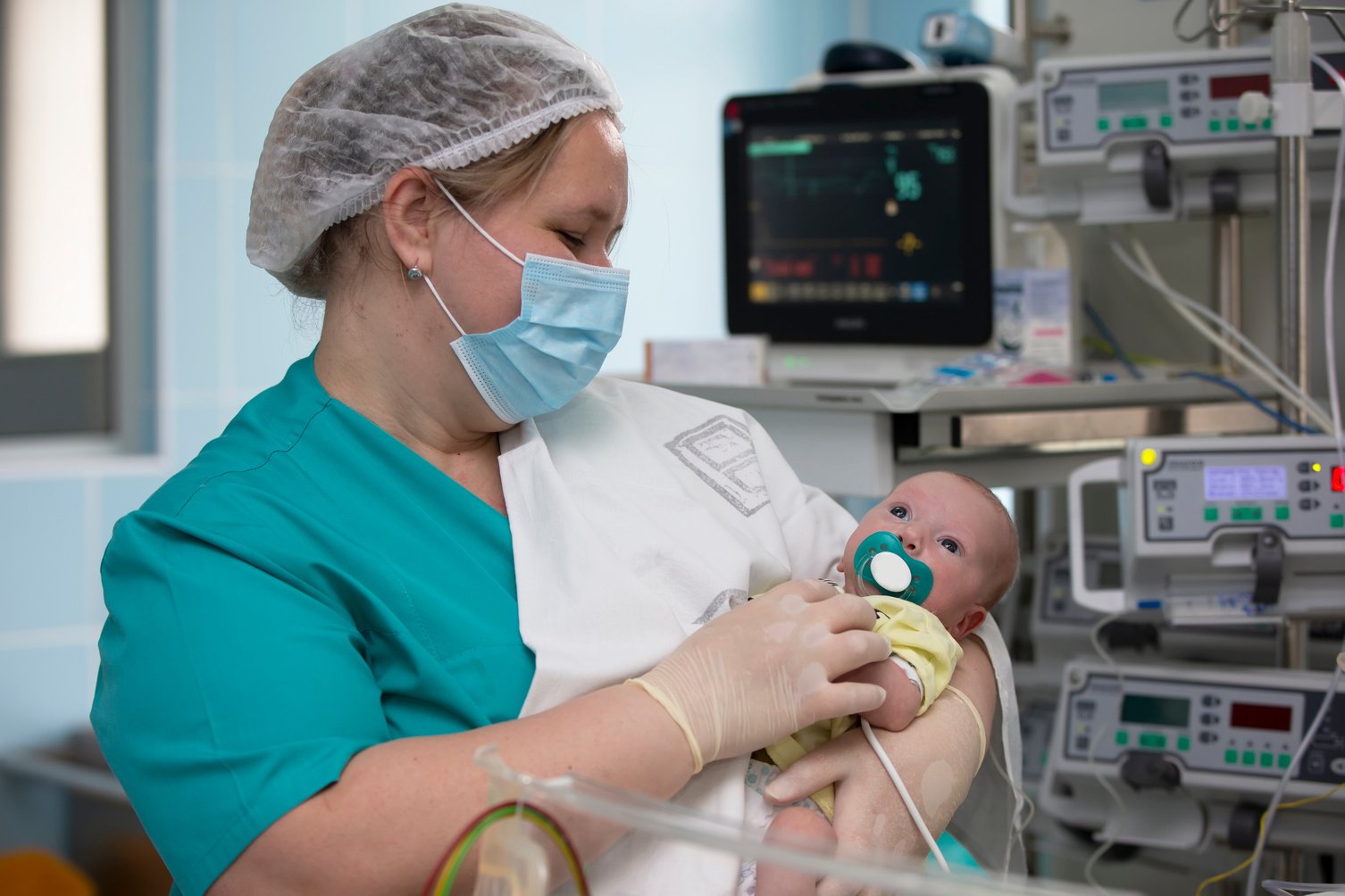 Nurse with a baby in intensive care. Newborn baby in the hospital.