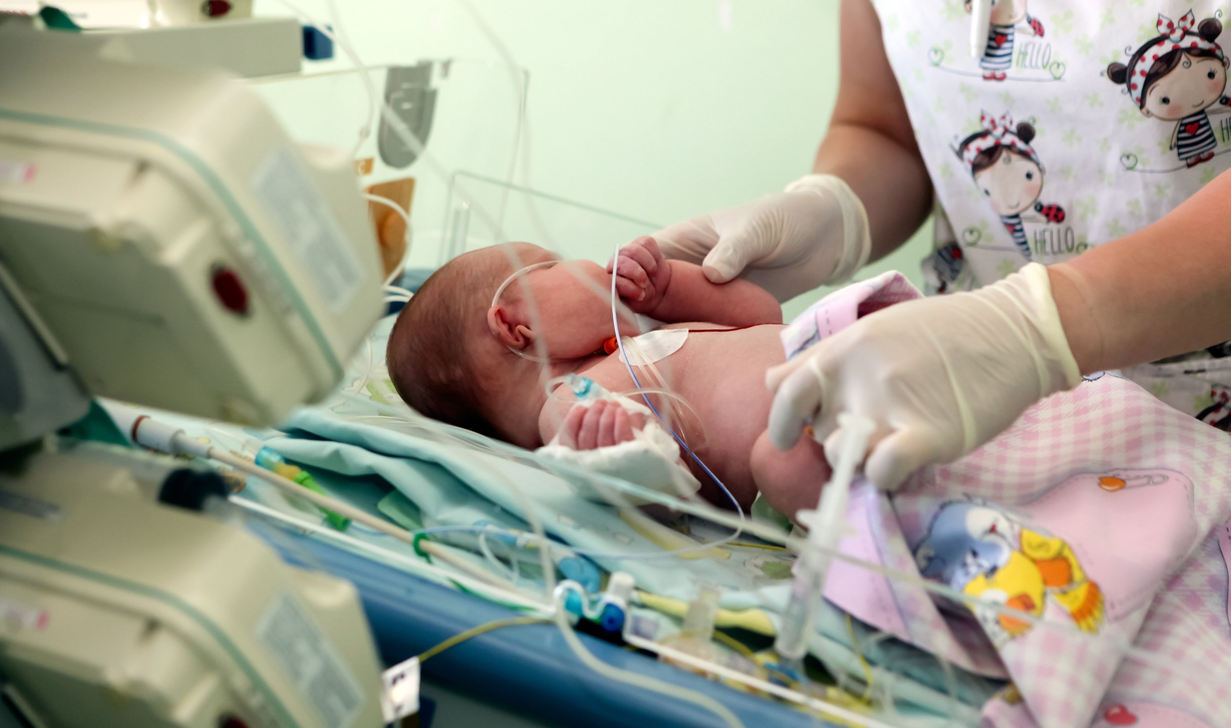 Young Female Nurse Holding a Newborn Baby in Hospital